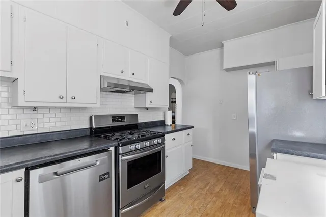 a kitchen with stainless steel appliances white cabinets and a stove