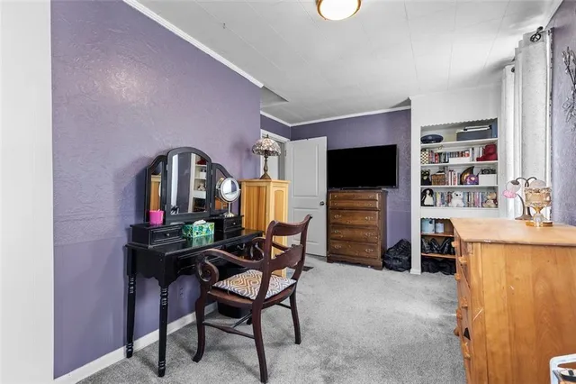 a living room with furniture a flat screen tv and a refrigerator