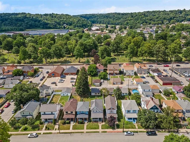 an aerial view of residential houses with outdoor space and parking