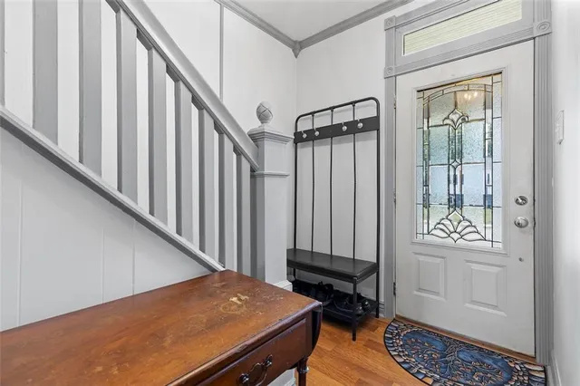 a view of a hallway with wooden floor and staircase