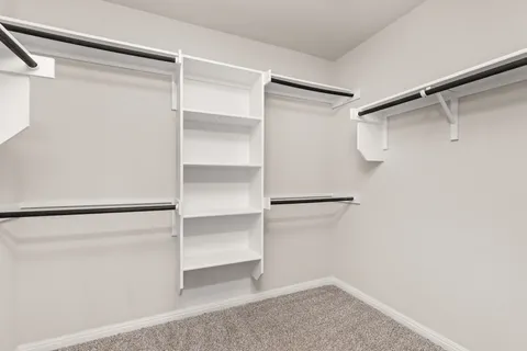 a view of walk in closet with empty racks