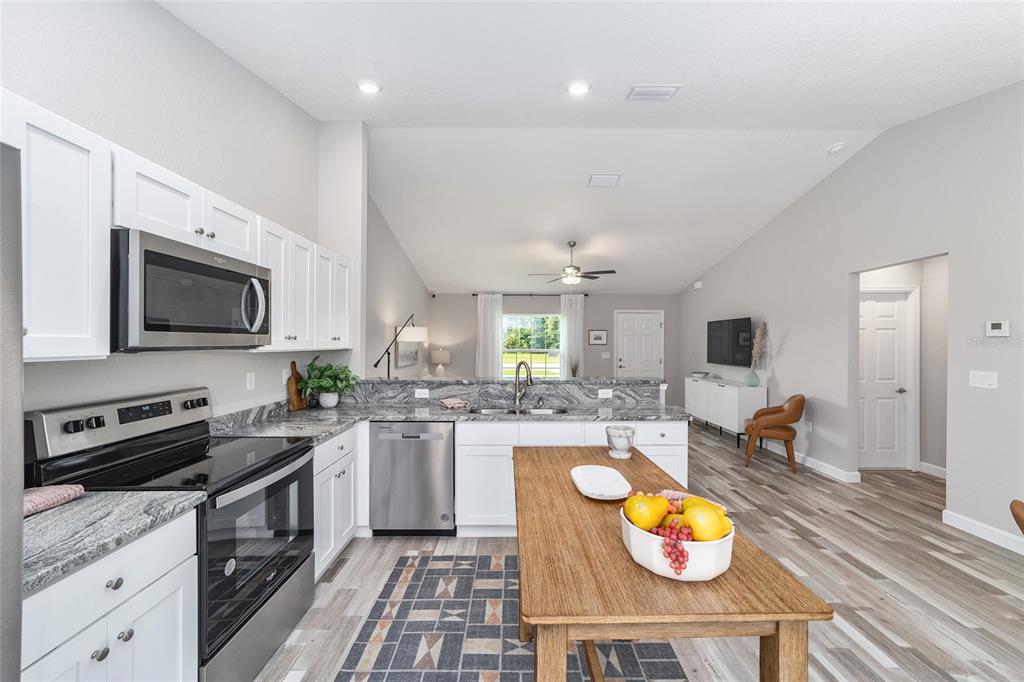 8571 Southwest 131st Place Ocala, FL 34473 - Photo 18 of 32 a kitchen with a stove a sink and a microwave