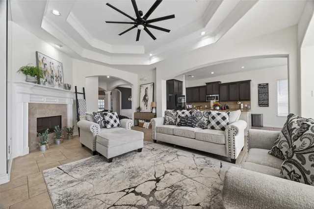a living room with furniture a fireplace and a chandelier
