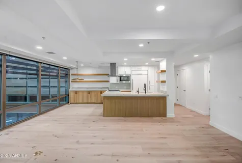 a view of kitchen with kitchen island a sink wooden floor and a counter top space