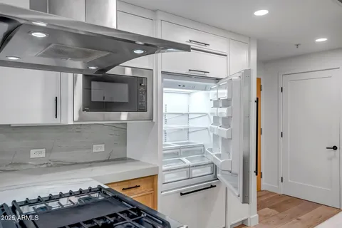 a kitchen with stainless steel appliances kitchen island granite countertop a stove and a refrigerator