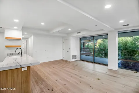 a open kitchen with kitchen island a sink wooden floor and a large window