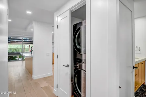 a view of a hallway with wooden floor and a bathroom