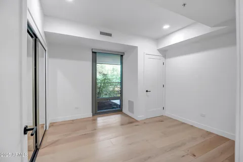 an empty room with wooden floor and a window