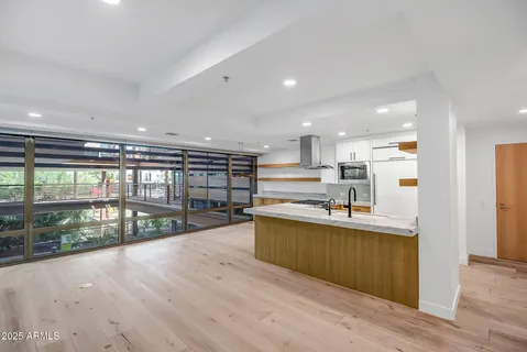 a kitchen with stainless steel appliances kitchen island wooden cabinets and wooden floor