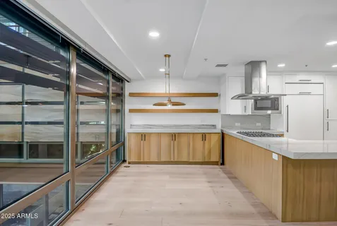 a large kitchen with stainless steel appliances kitchen island granite countertop a large cabinets a sink and a stove