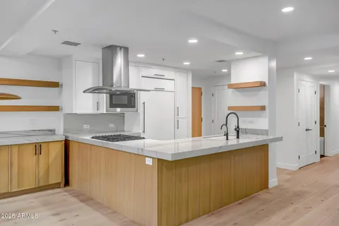 a kitchen with stainless steel appliances granite countertop a sink a stove and a refrigerator