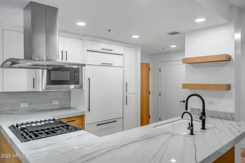 a kitchen with stainless steel appliances kitchen island a sink a stove and a refrigerator
