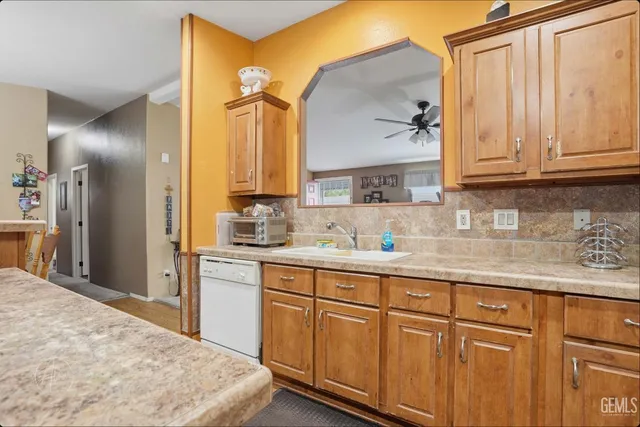 a kitchen with stainless steel appliances granite countertop a sink and cabinets with wooden floor