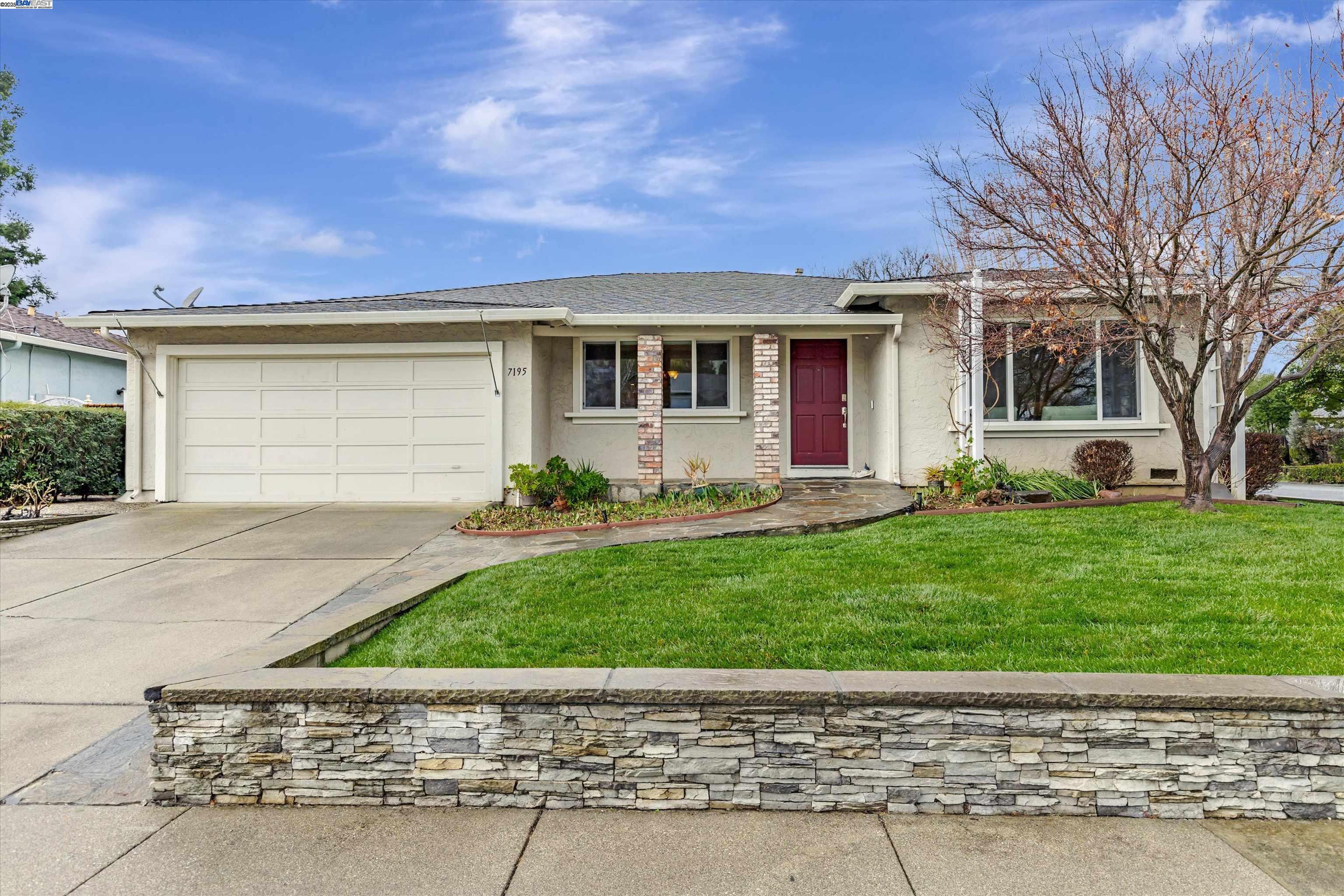 a front view of a house with a garden and yard