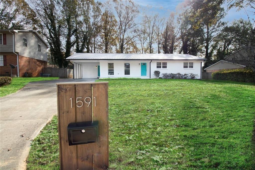 a view of a house with yard and trees