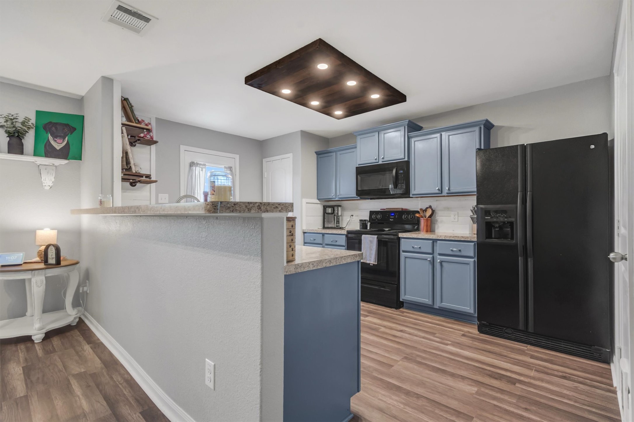 100 Wincliff Cove, Unit 13D Jarrell, TX 76537 - Photo 4 of 21 A well-equipped kitchen. Light fixture handmade by owner, ample cabinetry, and rich wood flooring.