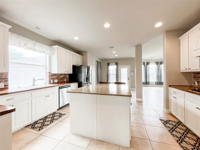 a large white kitchen with cabinets and a window
