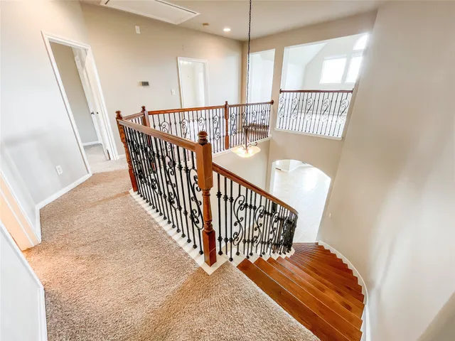 a view of staircase with railing and white walls