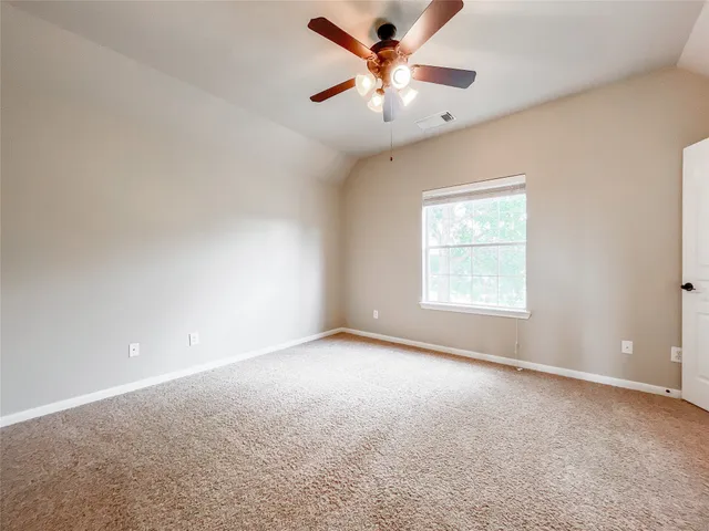 an empty room with a window and a fan