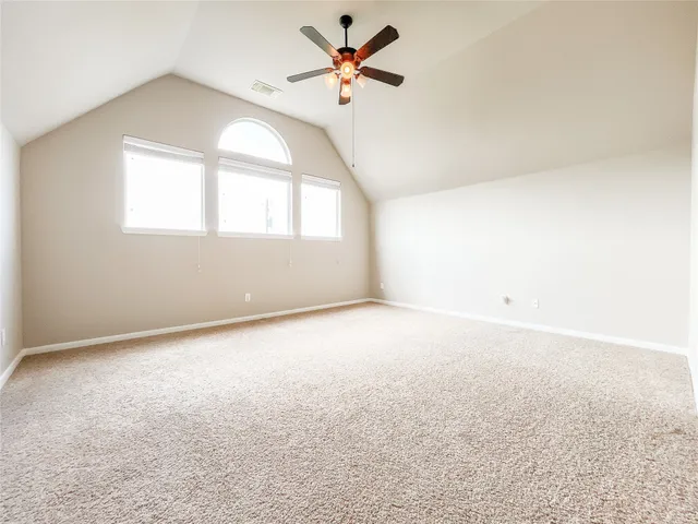 an empty room with a window and a ceiling fan