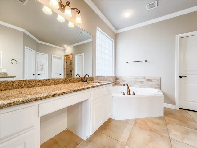 a spacious bathroom with a sink double vanity granite and a mirror