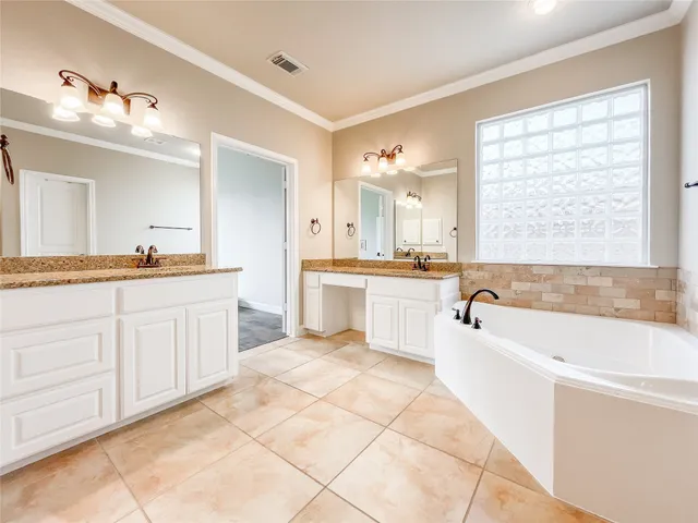 a spacious bathroom with a double vanity sink a mirror a bathtub and next to a window