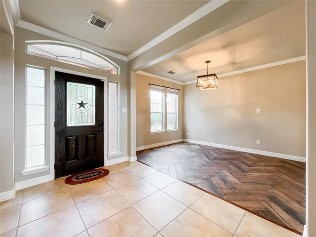 a view of a hallway with wooden floor and windows