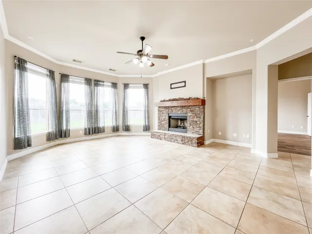 a view of an empty room with a fireplace and a window