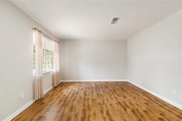a view of a room with wooden floor and white walls