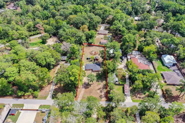 an aerial view of residential house with outdoor space and trees all around