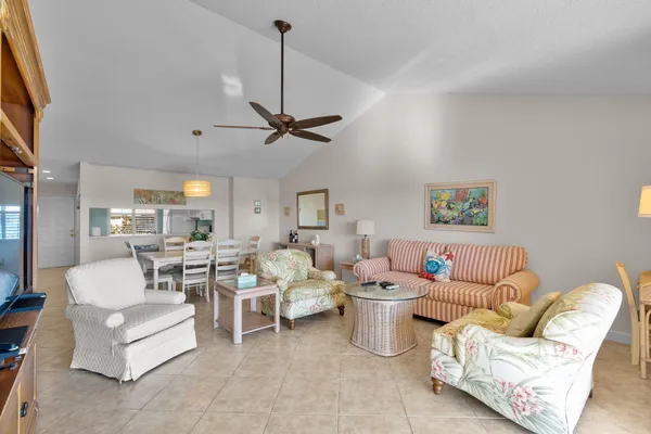 a living room with furniture a flat screen tv and kitchen view