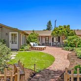 a view of a house with backyard and sitting area
