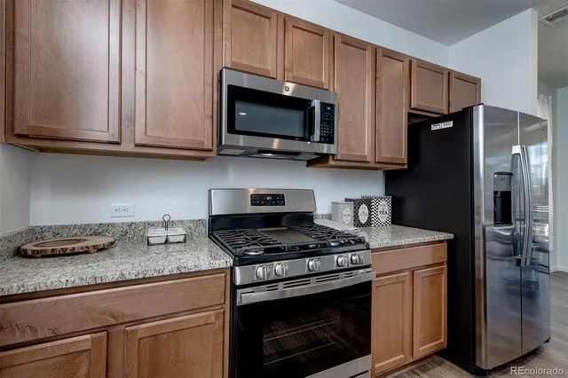 a kitchen with stainless steel appliances granite countertop a stove microwave and refrigerator