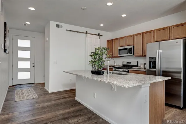 a kitchen with kitchen island a counter top space cabinets and stainless steel appliances