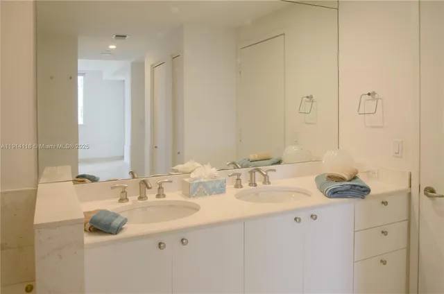 a bathroom with a double vanity sink and a mirror