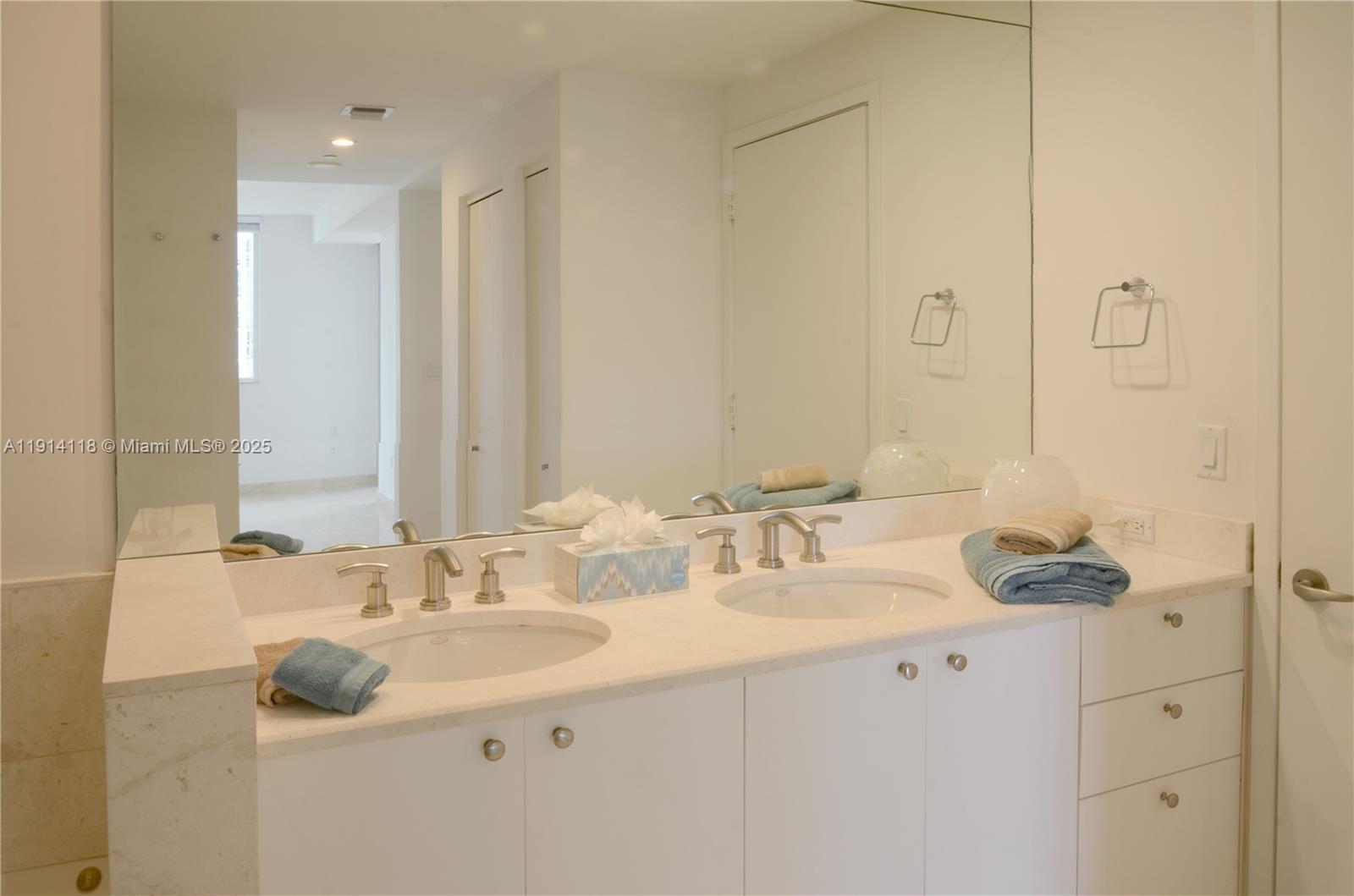 901 Brickell Key Boulevard, Unit 705 Miami, FL 33131 - Photo 12 of 41 a bathroom with a double vanity sink and a mirror