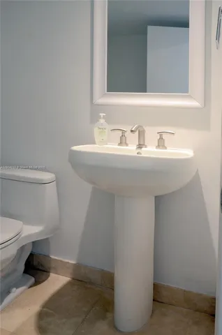 a bathroom with a sink toilet and a mirror