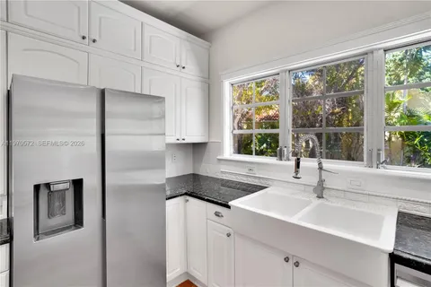 a kitchen with stainless steel appliances granite countertop a sink and a refrigerator