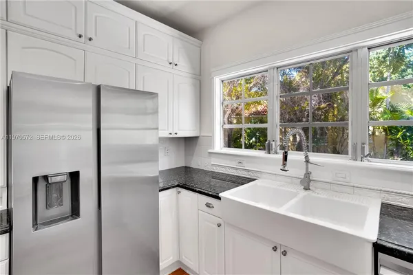 a kitchen with granite countertop a sink stove and cabinets
