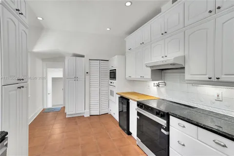 a kitchen with stainless steel appliances granite countertop a sink a stove and a refrigerator