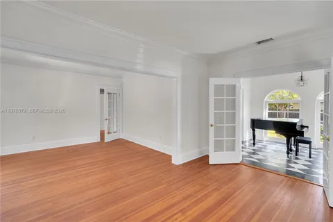 a view of a room with wooden floor fireplace and windows
