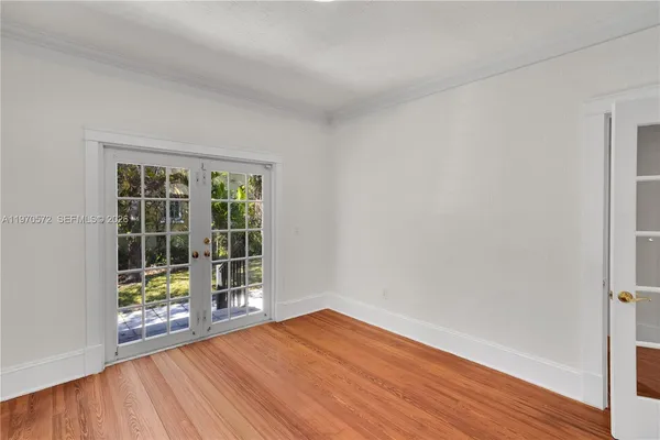 a view of empty room with wooden floor