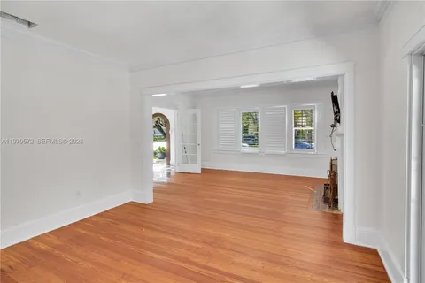 a view of empty room with wooden floor
