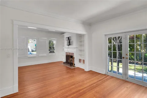 a view of empty room with wooden floor and fireplace