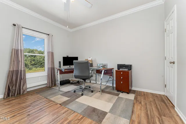 a view of a workspace with wooden floor and a window