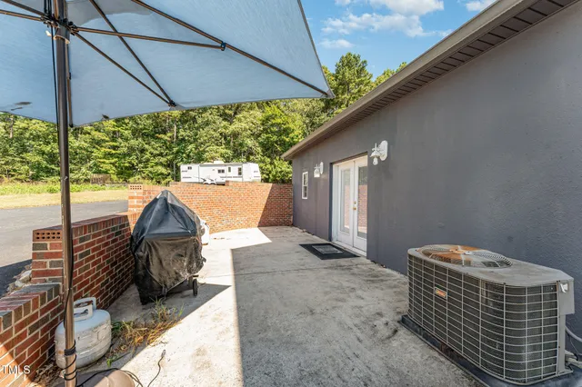a view of a patio with a table and chairs under an umbrella