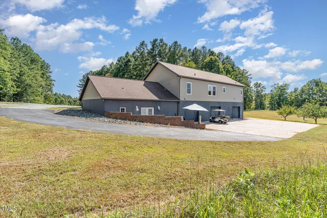 a view of a house with pool and a yard
