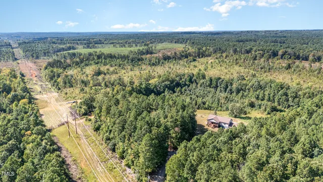 an aerial view of a houses with a yard and lake view