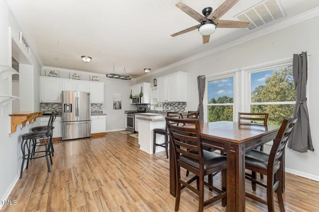 a dining room with furniture and a kitchen view