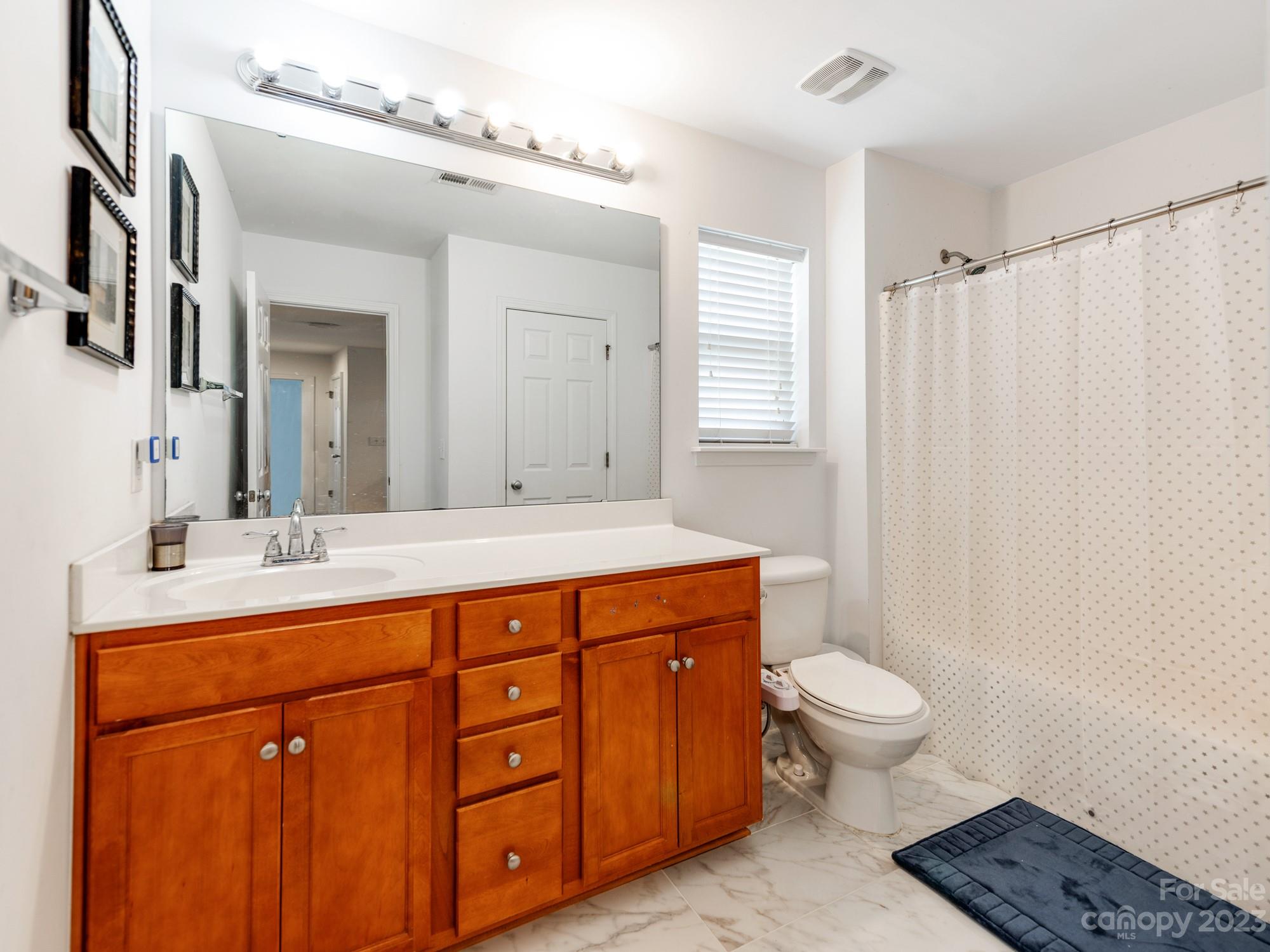 4409 Lawrence Daniel Drive Matthews, NC 28104 - Photo 32 of 38 a spacious bathroom with double sink a toilet a mirror and shower